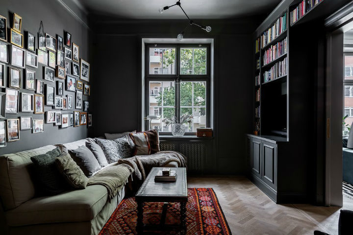 small living room with black walls and green sofa