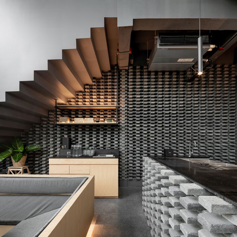 The bar and the wall adjacent to it feature a grey brick pattern that contrasts with the warm wooden surfaces around it