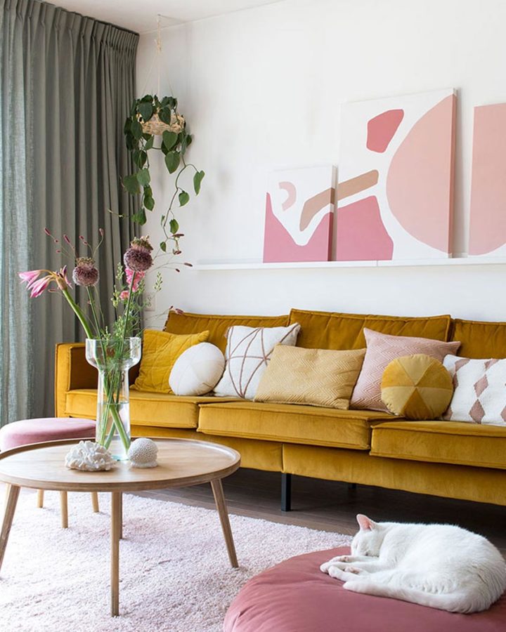 living-room with yellow velvet modern sofa and pink wall art