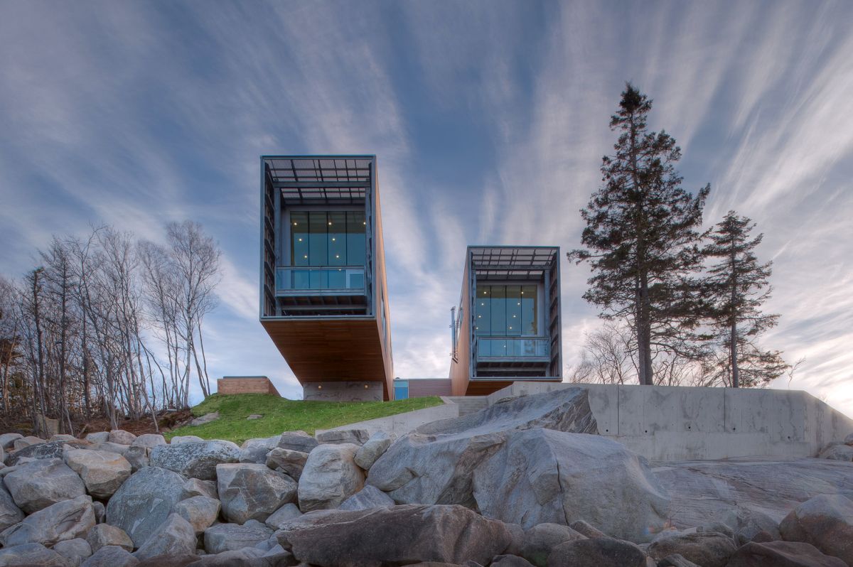 The pavilions have steel frames covered in a wooden skin and end in terraces with glass railings