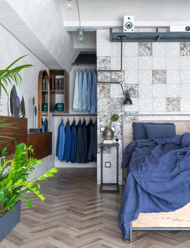 loft bedroom with wood flooring open wardrobe and stucco on walls and ceilings