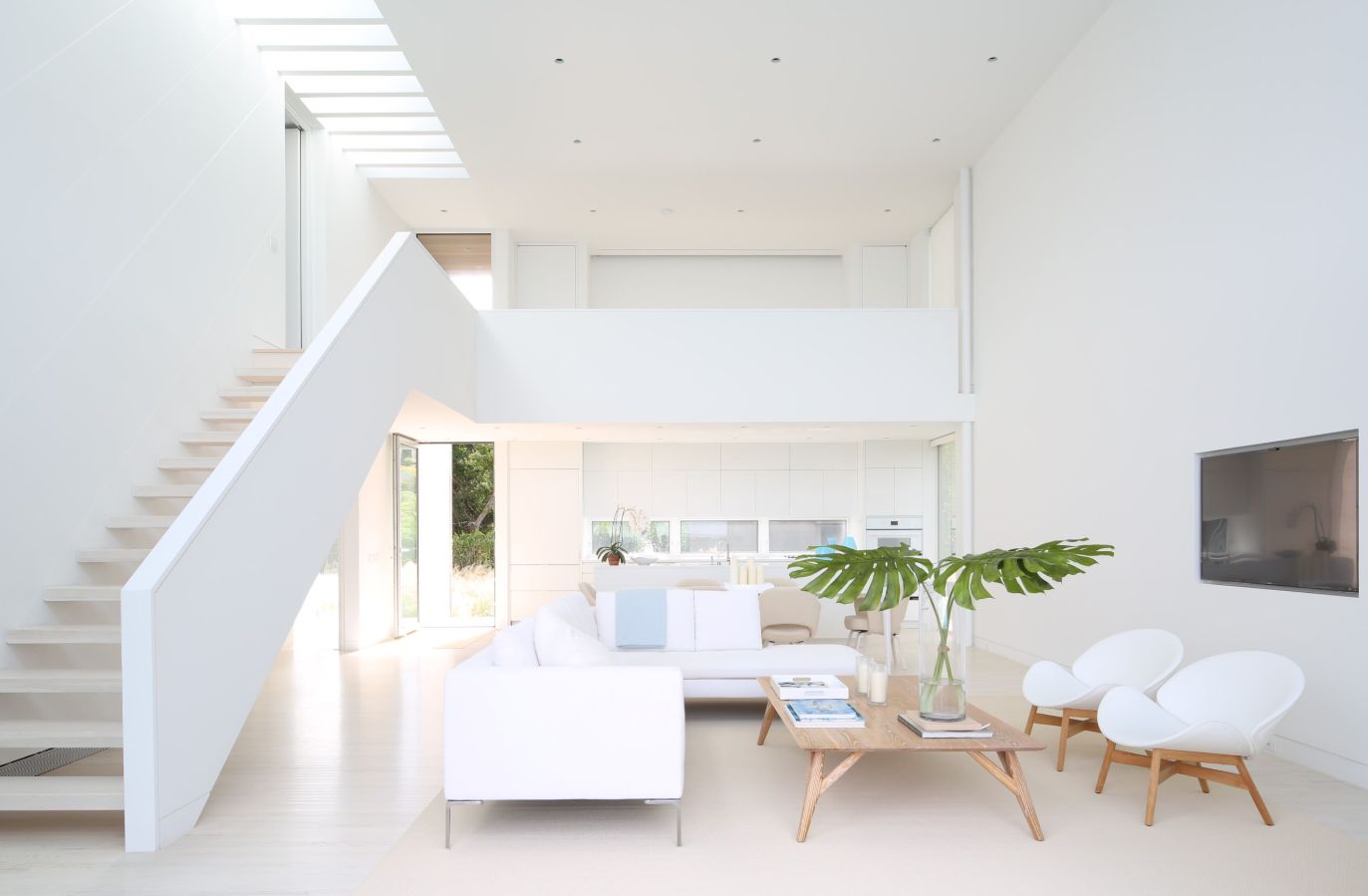 Pure white furniture and matching walls, floors and ceilings make this space seem bright despite the lack of windows