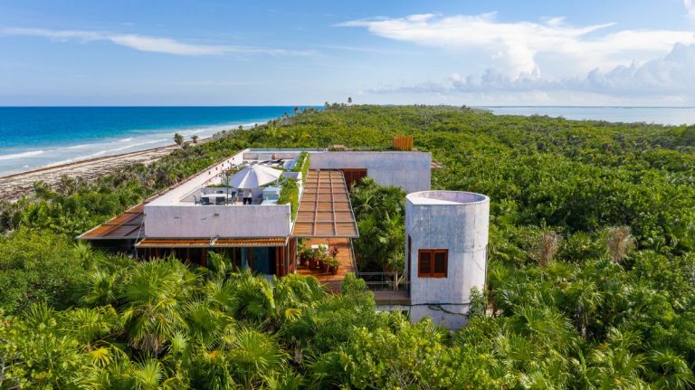 A Tropical Beachfront House Surrounded By Jungle And Lush Greenery